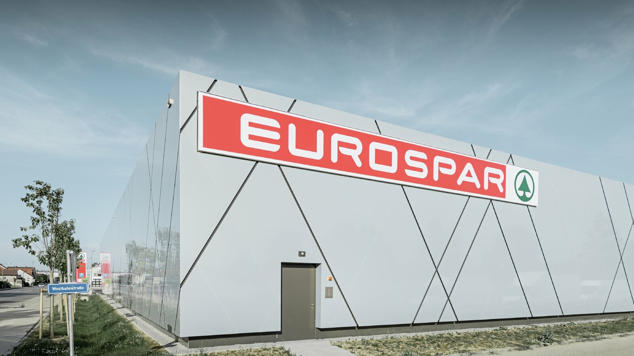 Zadnja stran nove podružnice Eurospar v Welsu; fasada je oblečena v aluminijaste kompozitne plošče PREFA v edinstveno srebrno zlati barvi.