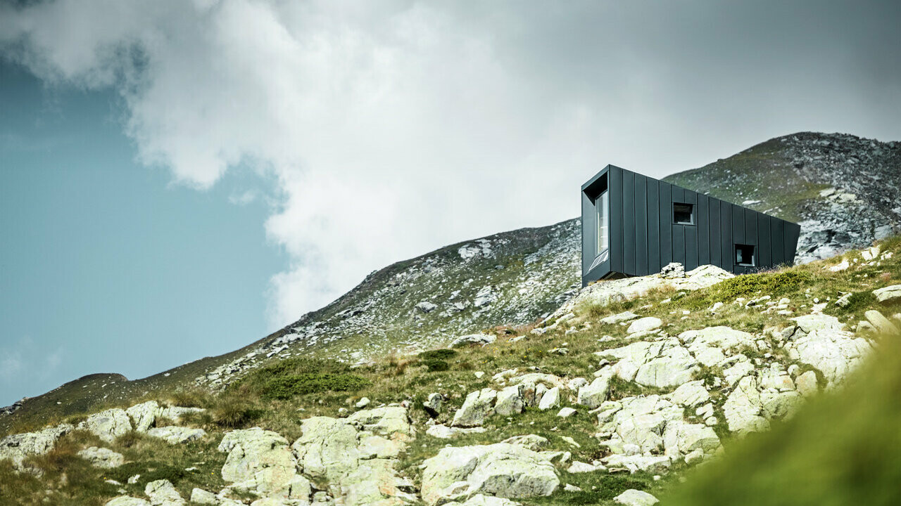 Totalansicht auf die Bivacco Brédy Hütte in den italienischen Alpen. Verkleidet wurde die Hütte rundherum mit PREFALZ in der Farbe P.10 Anthrazit.