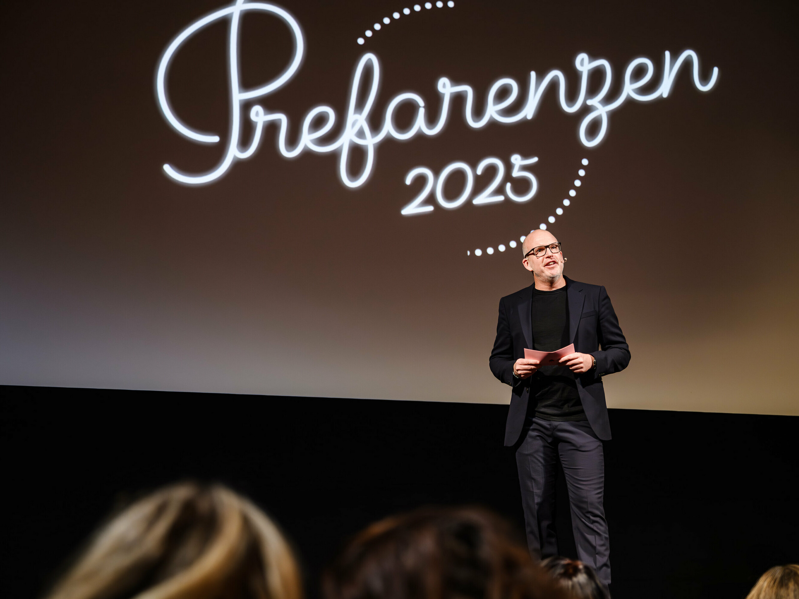 Jürgen Jungmair, Marketingleiter von PREFA, hält eine Rede bei der PREFARENZEN-Premiere 2025 im Stadtkino Wien. Im Hintergrund ist das Logo der Veranstaltung ‚Prefarenzen 2025‘ zu sehen.